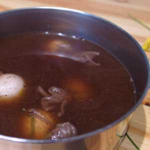 Coffee dyed egg process with eggs prepared and in sauce pan with coffee, water and vinegar